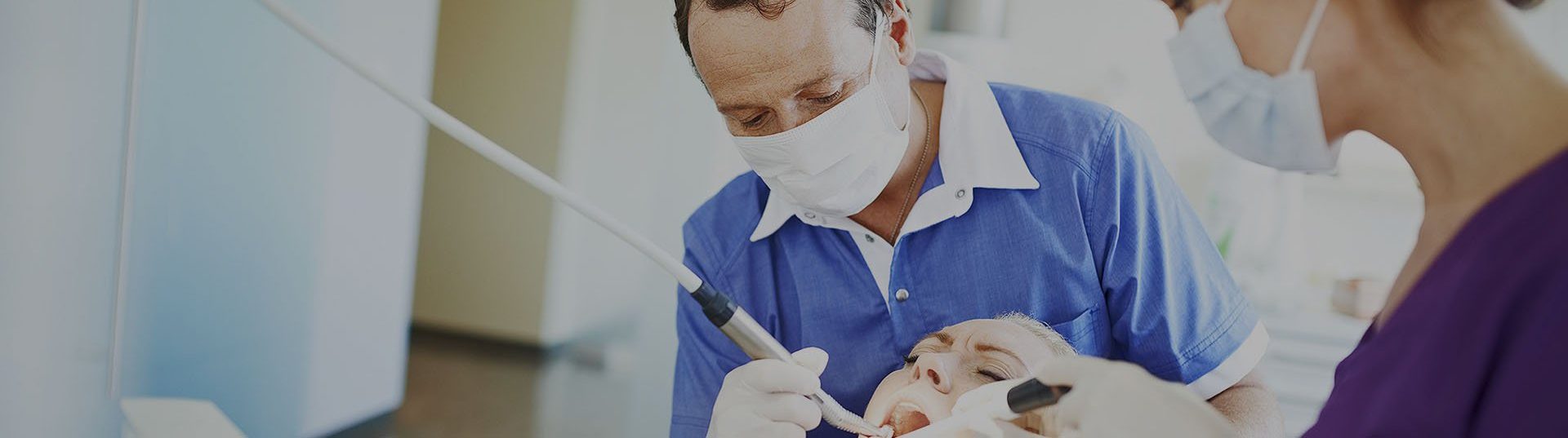 Dentists doing work on patient's teeth.