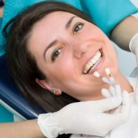 Dentist matching veneers to patients teeth.