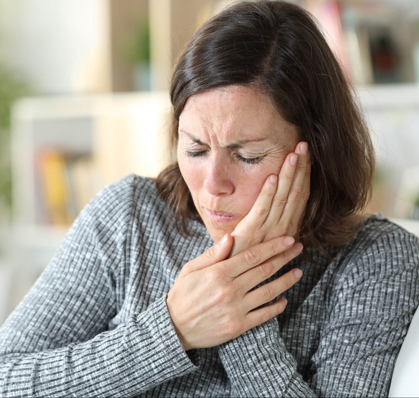 Women holding her mouth in pain.