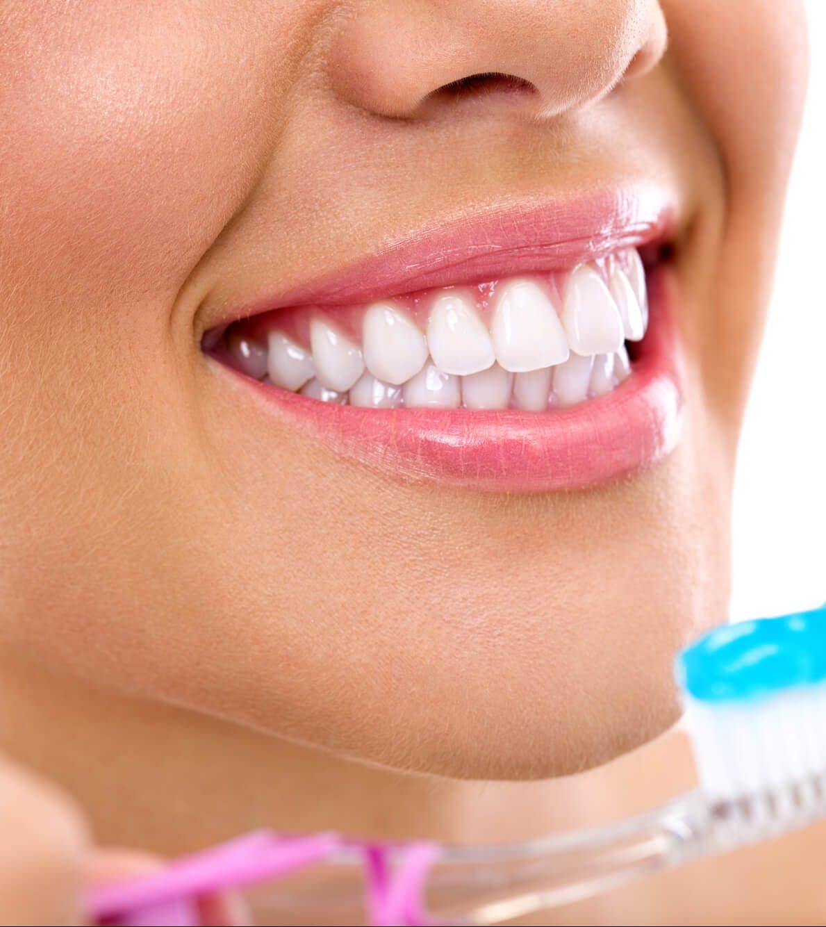 Lady with white teeth holding a toothbrush.