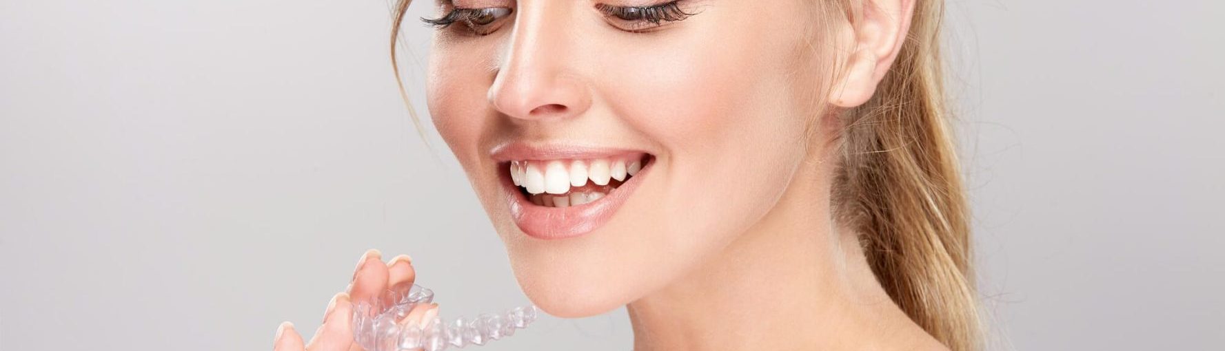 Lady holding Invisalign braces.