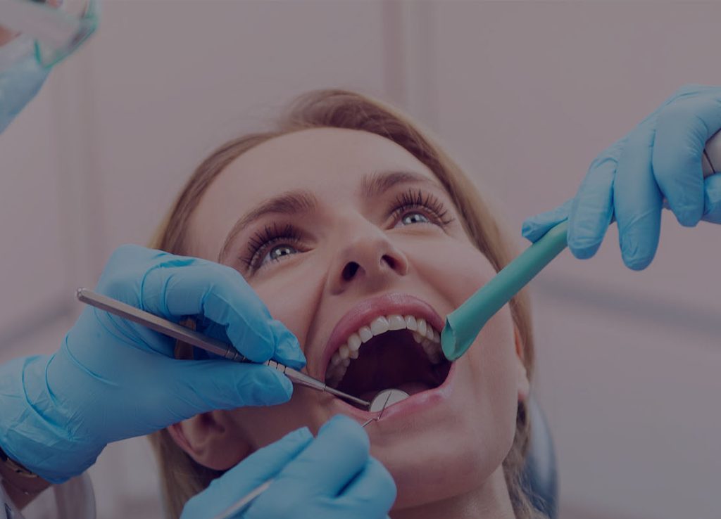 Dentist cleaning patient's mouth.