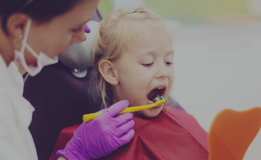 Dentist brushing child's teeth.